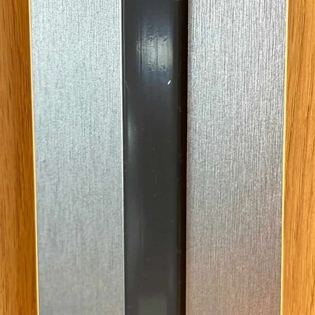 Overhead view demonstrating a black flush-fit LED light strip seamlessly embedded between modern acoustic wall panels for a clean, luxury finish.
