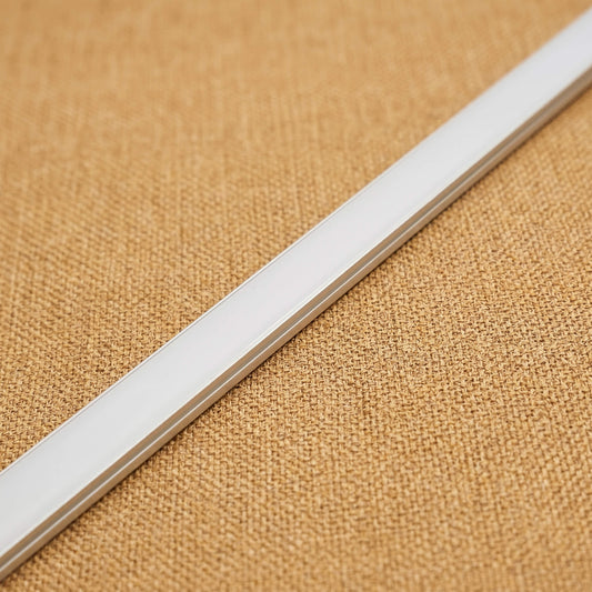 Close-up profile view of a trimless 10mm x 9mm white LED channel strip showcasing the flush-mount installation design on a textured light oak wood background.