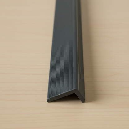 Detailed close-up of a Black minimalist composite edge trim, highlighting the textured surface and 15mm x 25mm profile for precise cladding finishes.