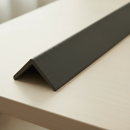 High-angle shot of a Dark Brown architectural trim resting on a light wood surface, highlighting its textured finish and clean lines.