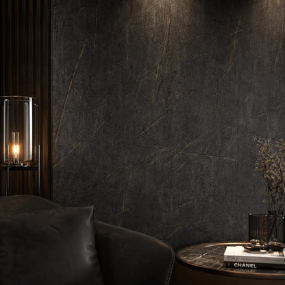 Mood lighting in a luxury living room setting showcasing a seamless dark marble PVC cladded wall behind a black leather armchair.