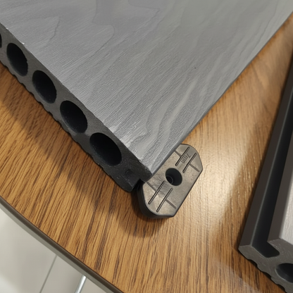 Hidden fitting being installed in the side groove of a Grey WPC decking board.