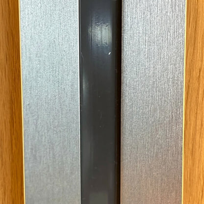 Overhead view demonstrating a black flush-fit LED light strip seamlessly embedded between modern acoustic wall panels for a clean, luxury finish.