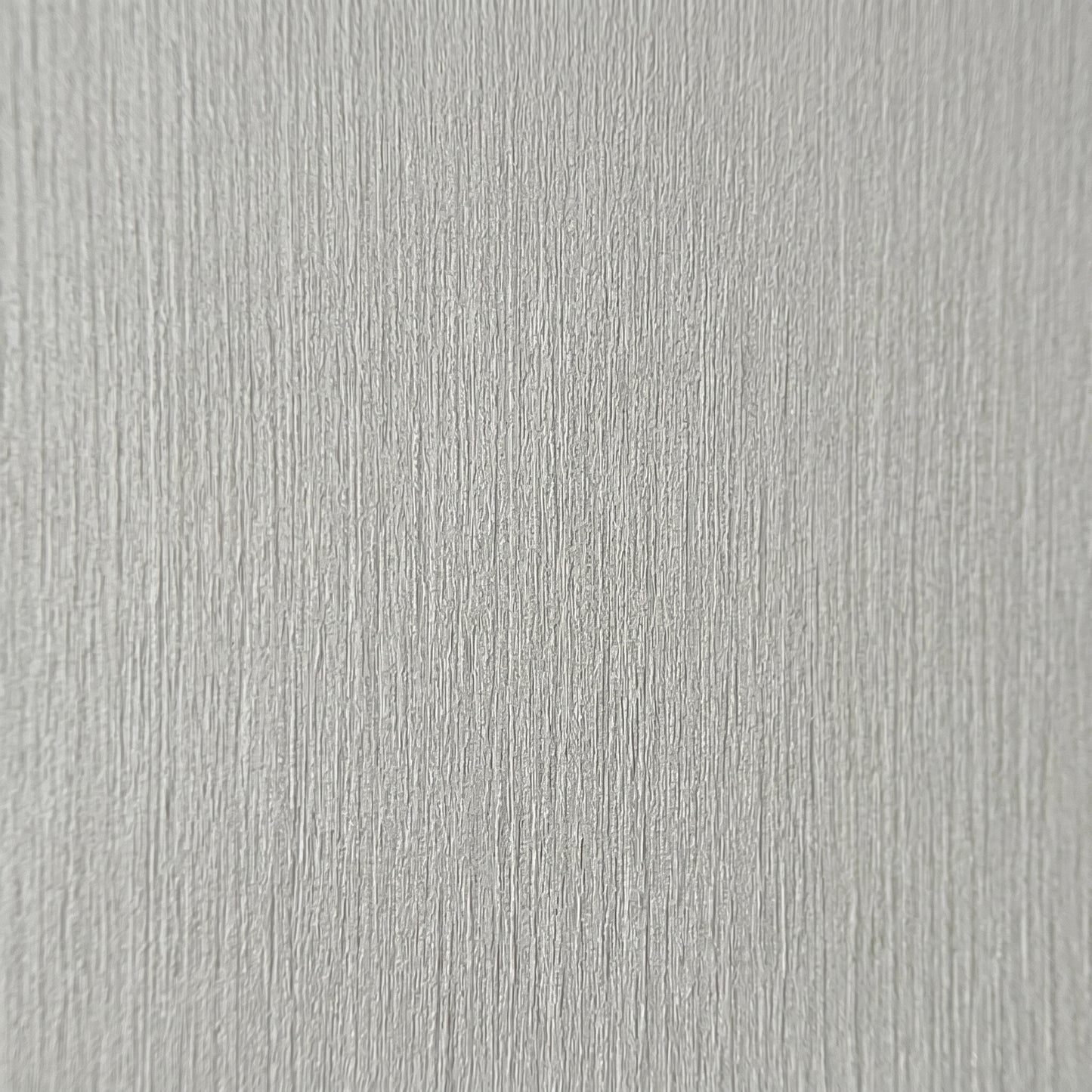 High-resolution macro zoom demonstrating the realistic architectural wood grain texture on the decorative finish of a grey premium SPC wall board.
