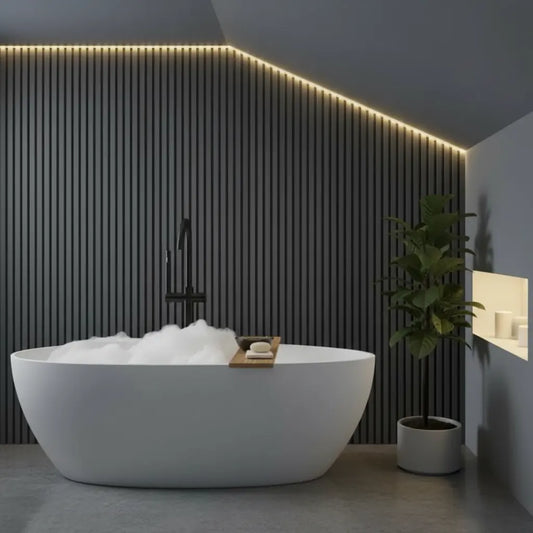 Modern bathroom interior featuring luxury dark grey PVC slat wall panels as an accent wall behind a white freestanding bathtub with ambient LED lighting.