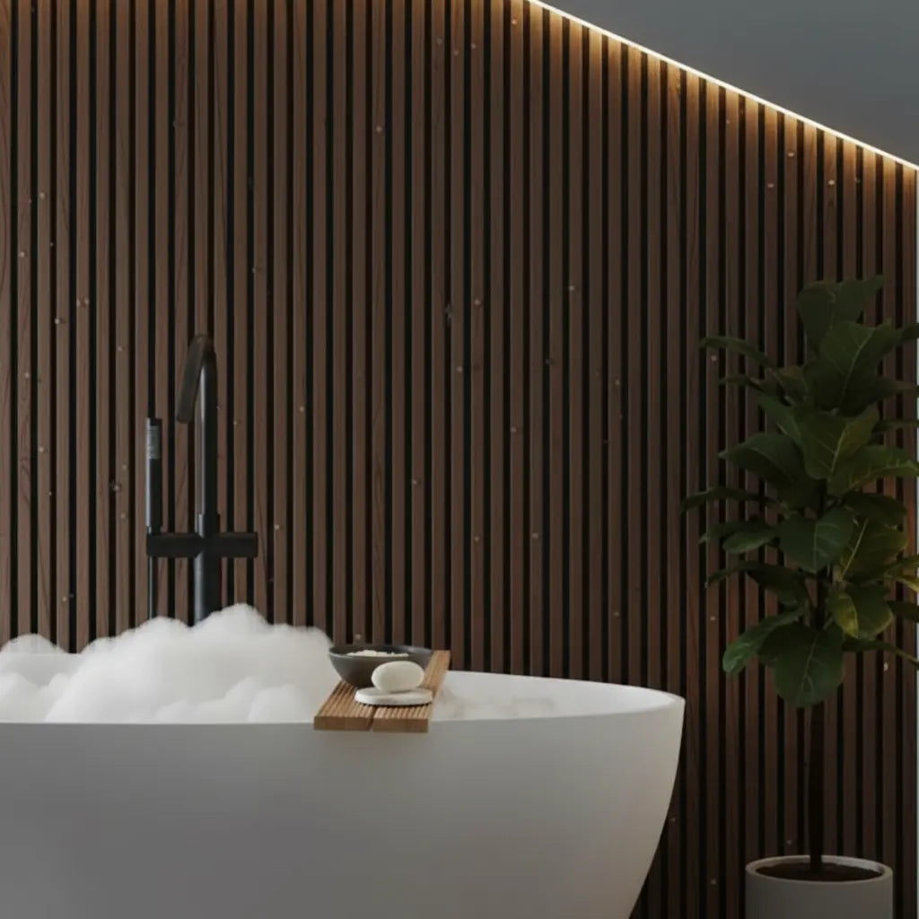 Luxury spa bathroom design featuring dark oak wood effect PVC slat wall panels behind a white freestanding bubble bath with warm accent lighting.