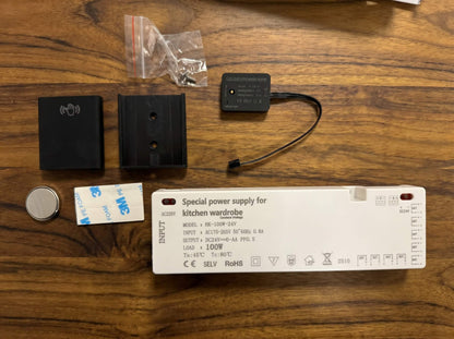 Complete unboxed components of the flexible wall panel LED kit including the power supply transformer, wall mount, remote control accessories, and wiring connectors.